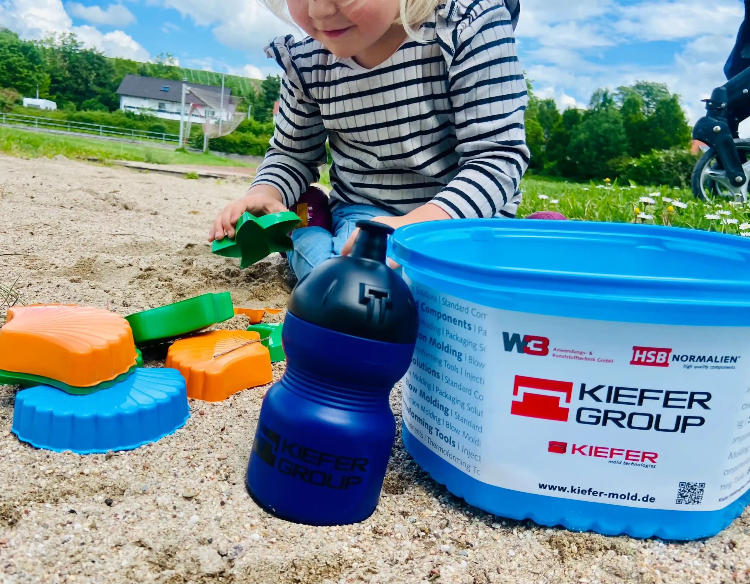 Child in a sandbox with plastic toys